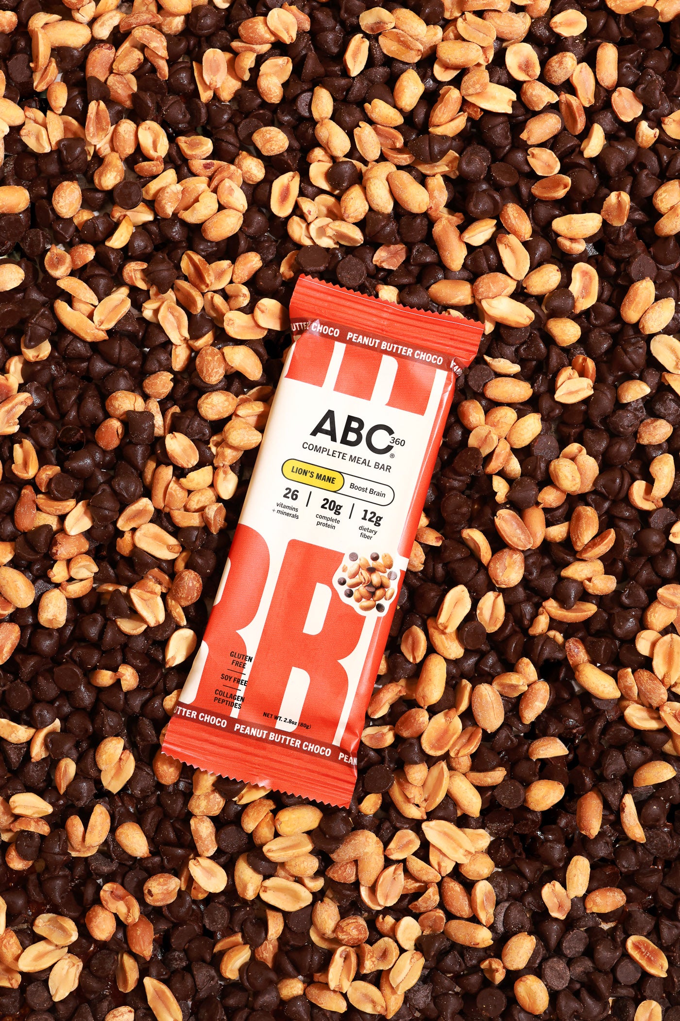 An ABC360BAR.COM Peanut Butter Choco bar with marine collagen protein rests on a surface sprinkled with chocolate chips and roasted peanuts.