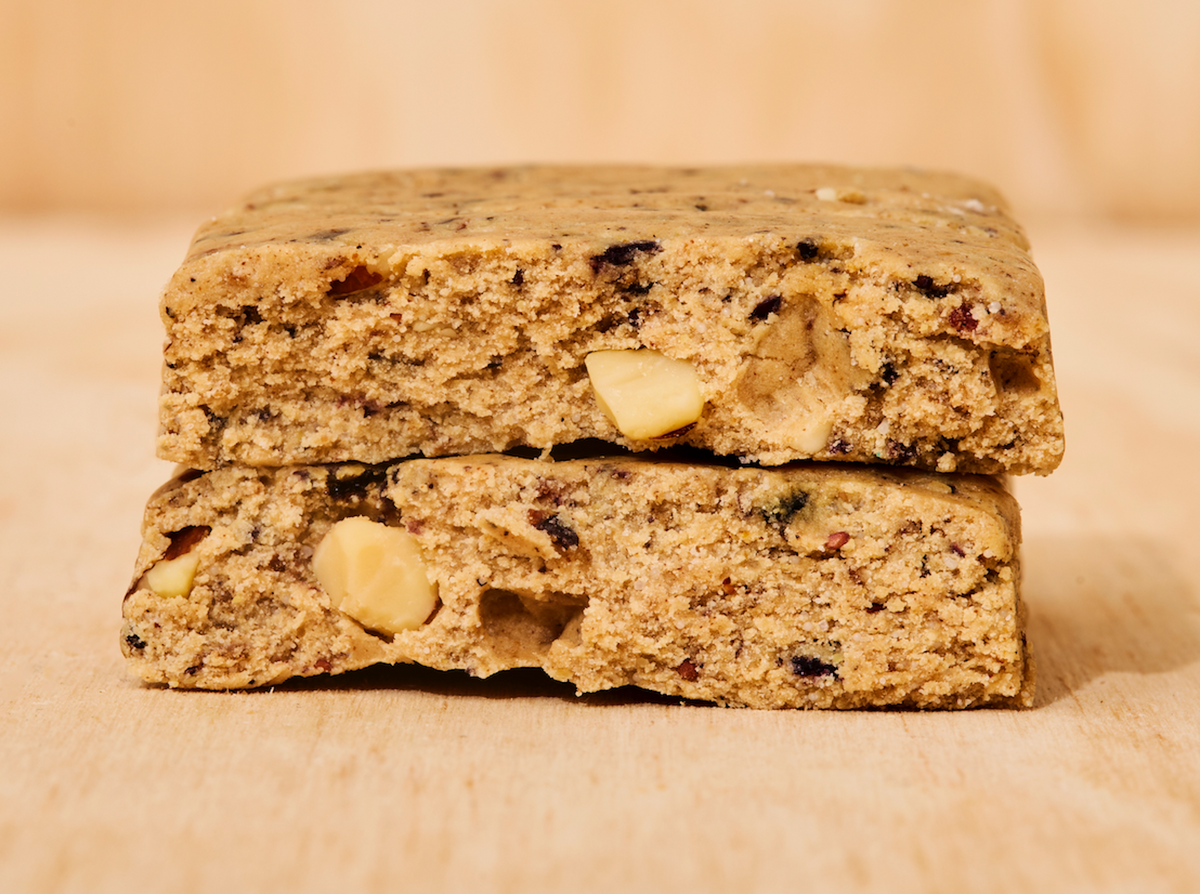 Two ABC 360® Blueberry Almond Protein Meal Bars stacked on a wooden surface, showing the inside