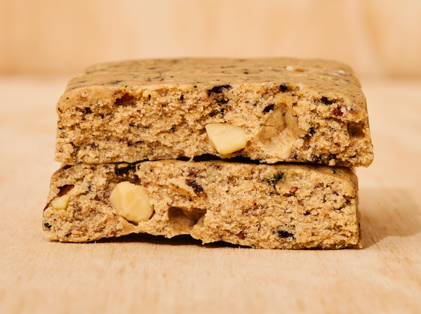 Two ABC 360® Blueberry Almond Protein Meal Bars stacked on a wooden surface, showing the inside