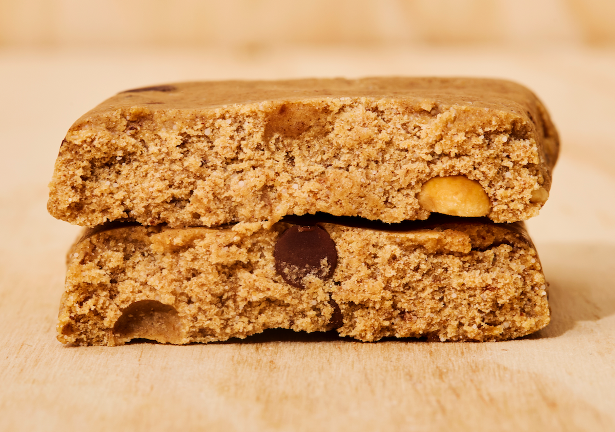Two ABC 360® Peanut Butter Choco Protein Meal Bars stacked on a wooden surface, showing the inside